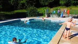 A swimming pool with clear blue water, surrounded by a stone deck and a fence. - Camping 3 étoiles - Piscine  - ccbfi0d (Mauroux)