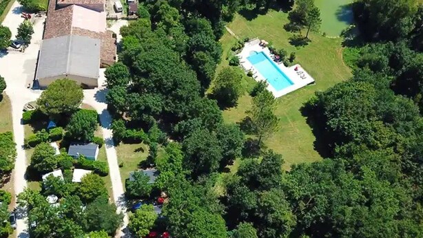 An aerial view of a residential area with a large house, a swimming pool, and surrounding greenery. - Camping 3 étoiles - Piscine  - ccbfi0d (Mauroux)