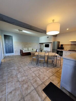 A spacious living area with a dining table, sofa, and kitchen area. - Camping 3 étoiles - Piscine  - ccbfi0h (Mauroux)