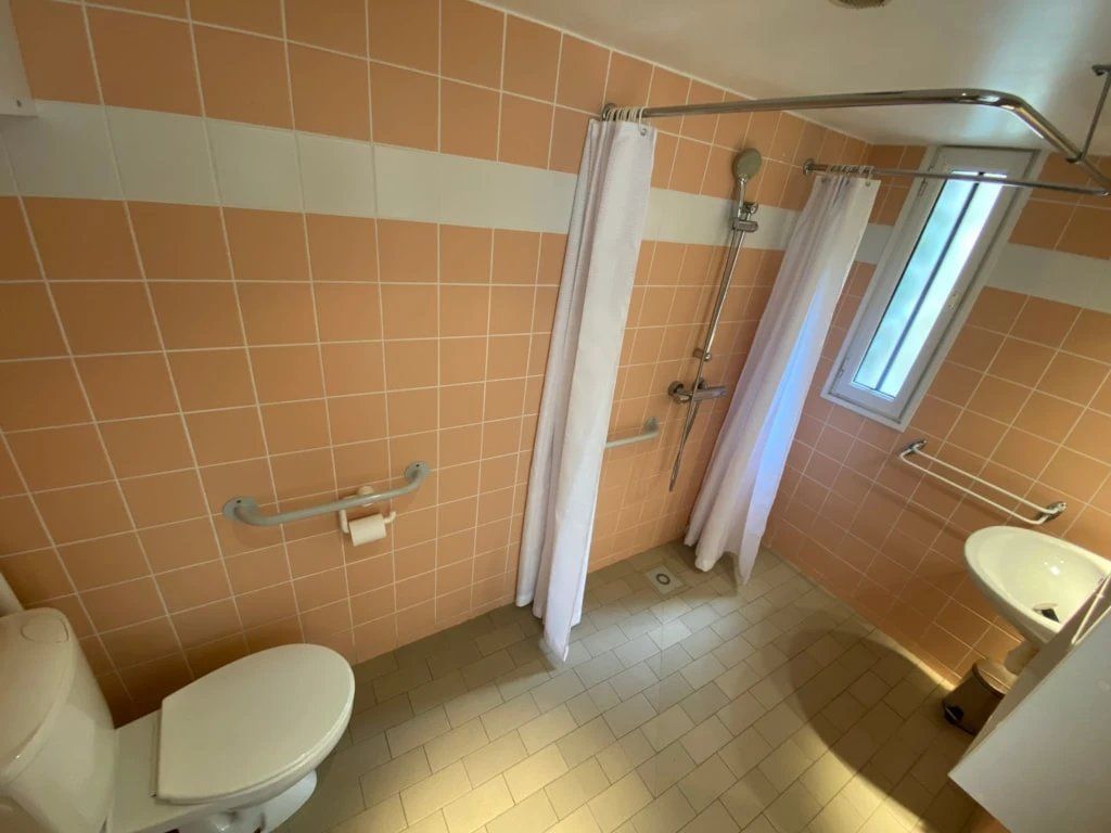 Une salle de bain avec des toilettes, une douche et un lavabo.
