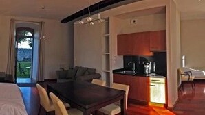 Habitación de hotel moderna con comedor, kitchenette y vistas a través de un ventanal.
