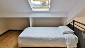 Una habitación con tragaluz, una cama y vistas al exterior.