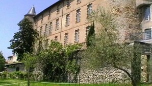 Un edificio grande y antiguo con varias ventanas y una pared de piedra.