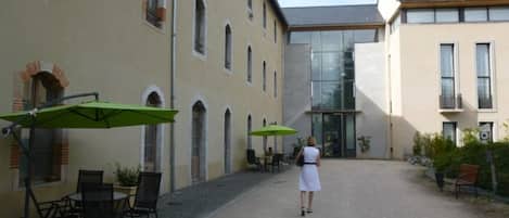 A courtyard with outdoor seating and a building entrance.