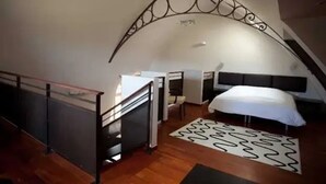 Um quarto com teto arredondado, cama, escrivaninha e cadeira.