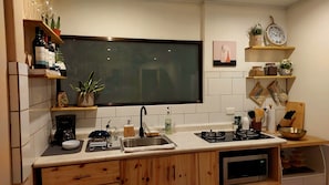 A modern kitchen with a large flat-screen TV, built-in oven, and various kitchen appliances. - 2-bedroom apartment in adorable Quepos with AC and comfort (Quepos)