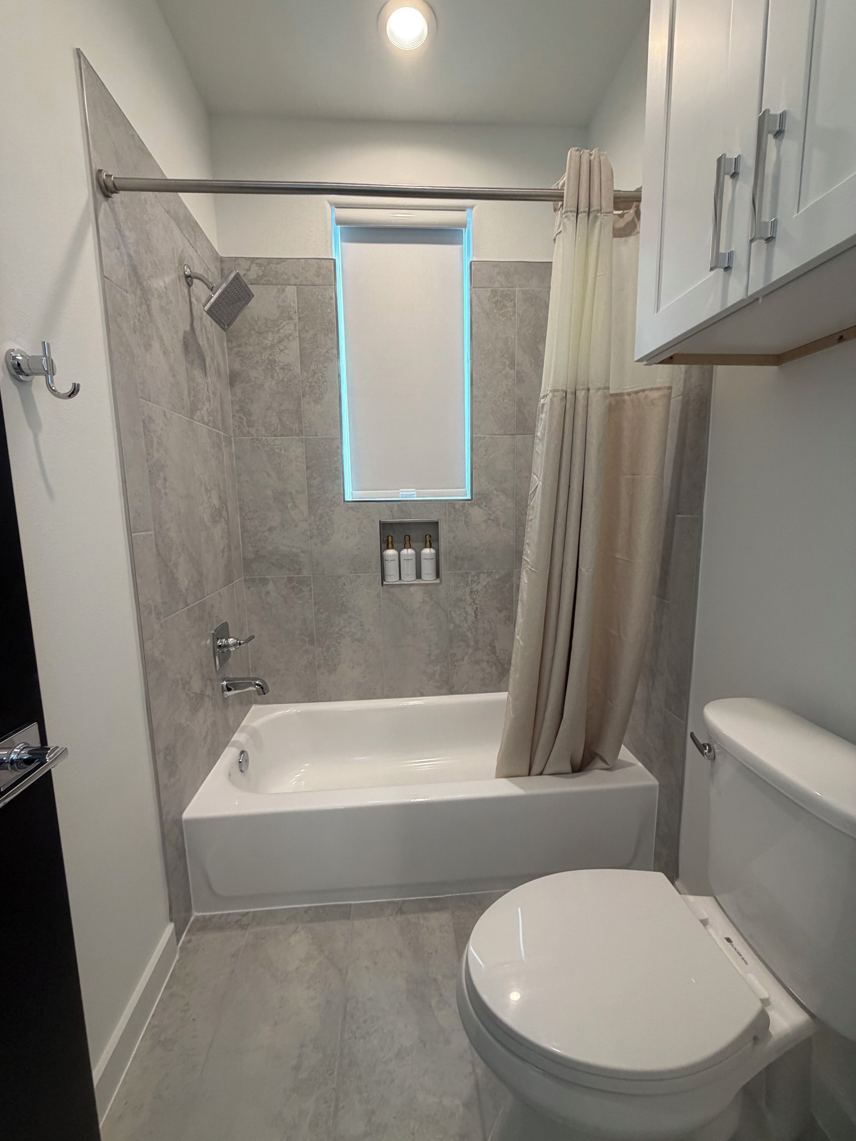 A bathroom with a bathtub, toilet, and a shower area.