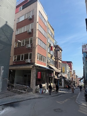 Un edificio de varios pisos con un letrero de mercado, una escalera y una fachada con la inscripción 'NICOLETTA'.