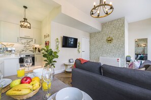 Un espacio habitable moderno con cocina, comedor y un sofá gris.