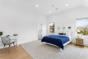 A bedroom with a bed, a desk, a chair, and a window. - Waterfront Retreat w/ Dock & Modern Design (Center Moriches)