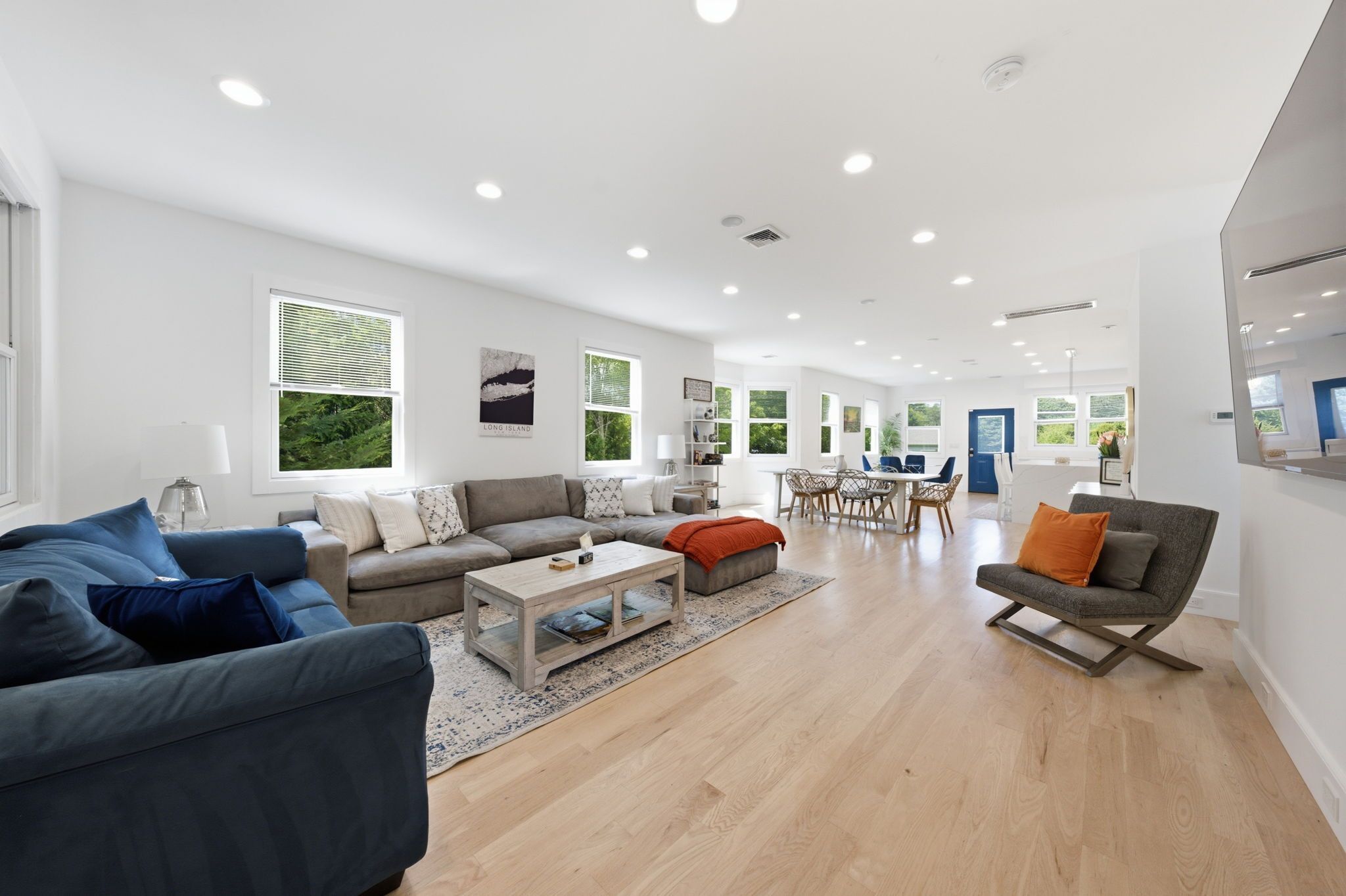 A spacious living area with a sofa, coffee table, and a dining table with chairs.