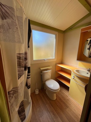 A compact bathroom with a toilet, sink, and window.