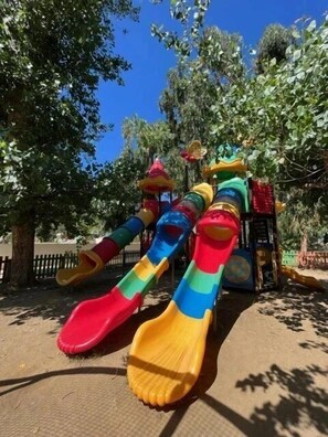 Une aire de jeux avec un toboggan et des structures d’escalade.