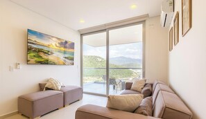 Ein Wohnzimmer mit großem Fenster, einem Gemälde und einem Sofa.