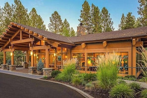 A lodge with a covered entrance, large windows, and a stone chimney. - 1BR Condo, Pool & Hot Tub, fitness center, trails (Bend)