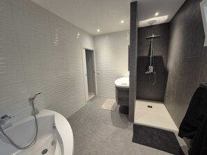 Une salle de bain moderne avec une baignoire, une douche et un lavabo.