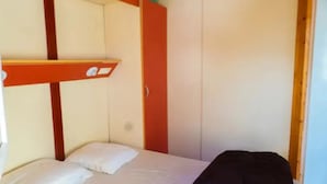 A bunk bed with a red frame, a single bed with white bedding, and a black bag on the floor. - Chalet 2 étoiles - Piscine  - ccbgdfh (Porto-Vecchio)