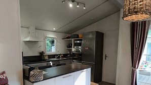 Een moderne keuken met witte kasten, een centraal eiland en inbouwapparatuur.