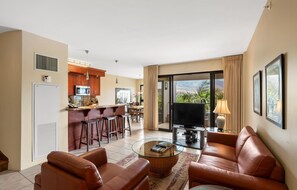 A modern living room with leather sofas, a coffee table, and a TV. - Kaanapali Alii-1 Bedroom Garden/Mountain Views (Lahaina)