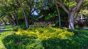 A sign with 'Kaanapali Ali' in the center of a well-maintained garden with various trees and shrubs. - Kaanapali Alii-1 Bedroom Ocean Views (Lahaina)