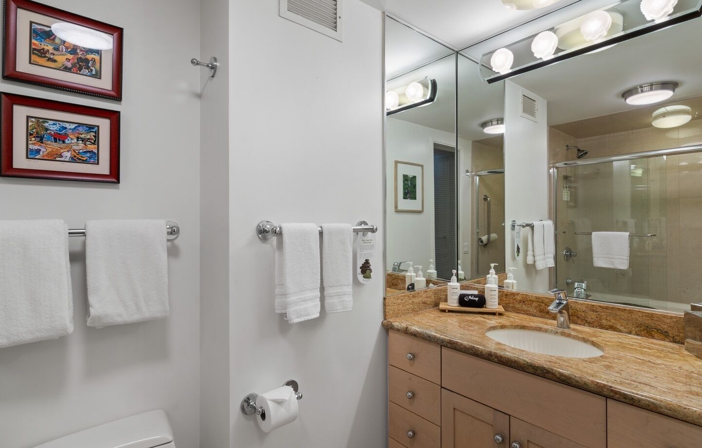 Un bagno con lavandino, specchio e porta asciugamani.