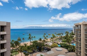 A resort with a pool, palm trees, and a view of the ocean. - Kaanapali Alii-2 Bedroom Partial Ocean Views (Lahaina)