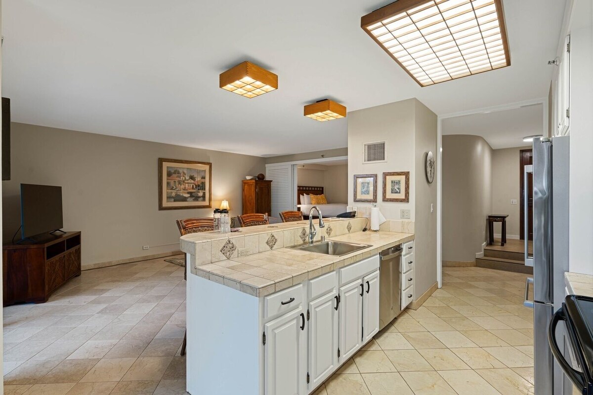 A modern kitchen with a central island, built-in cabinets, and pendant lighting.