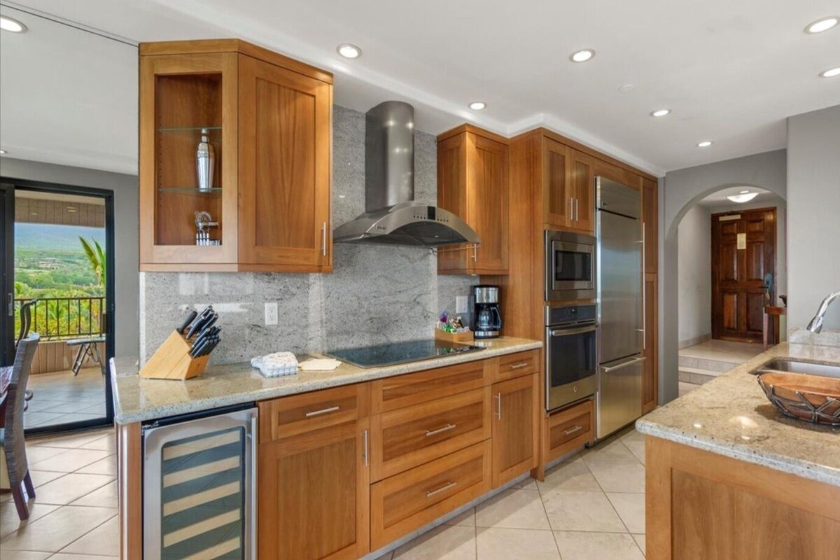 A modern kitchen with wooden cabinets, stainless steel appliances, and a granite countertop.