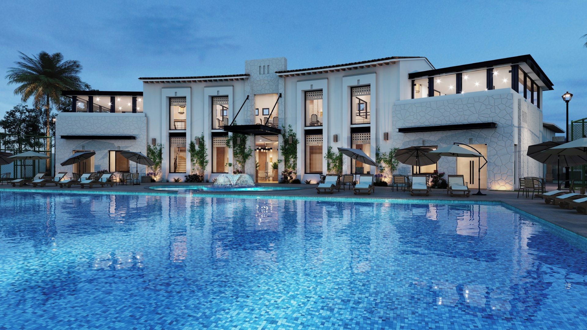 A modern hotel with a large swimming pool, sun loungers, and a well-lit entrance.