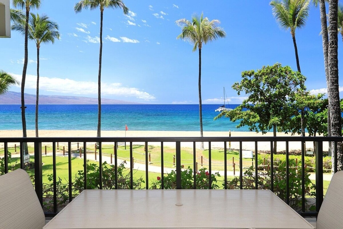 Ein Balkon mit Blick auf Strand, Meer, Palmen und ein Boot in der Ferne.