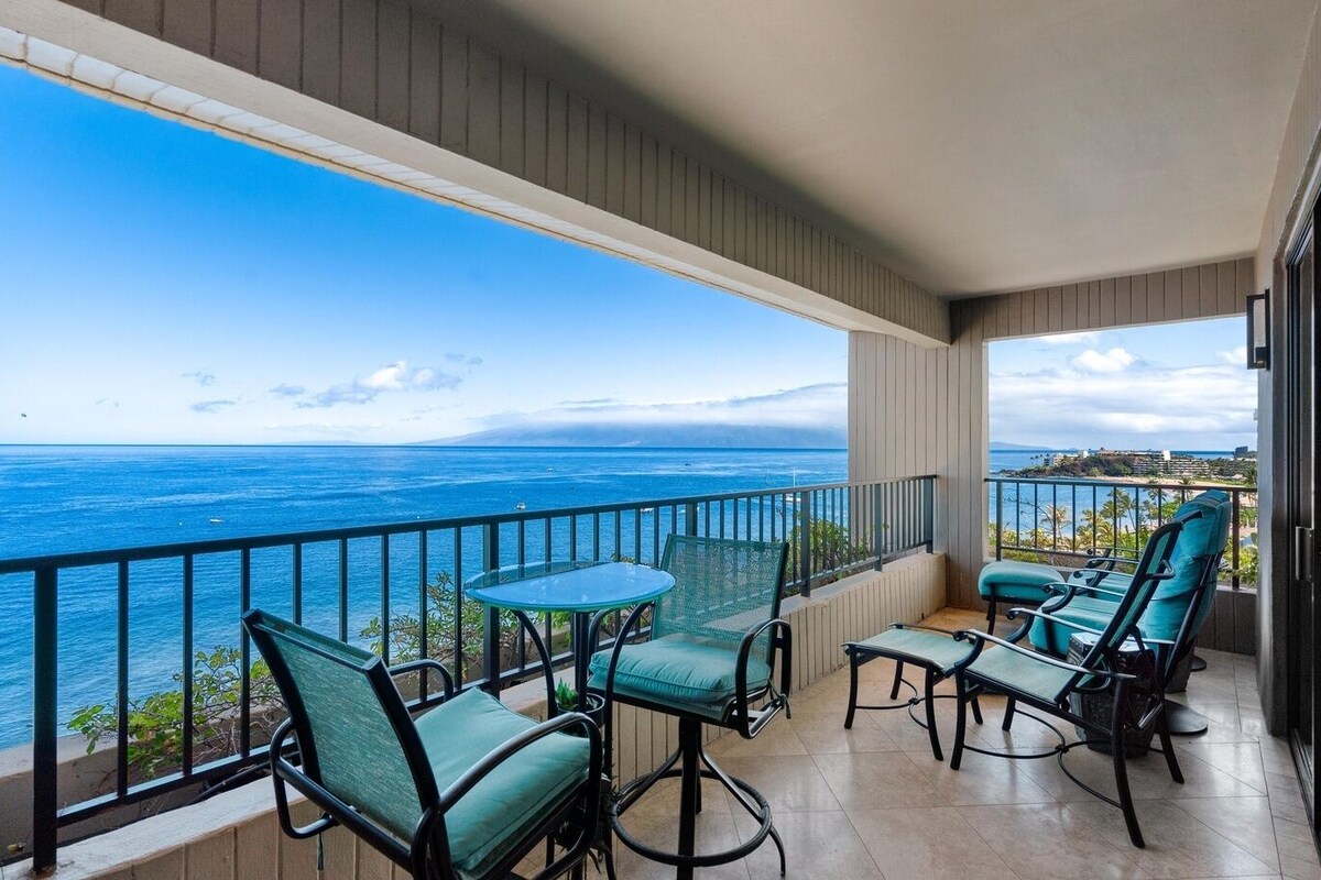 Ein Balkon mit Blick auf das Meer, ausgestattet mit Stühlen und einem Tisch.