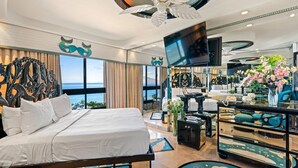 A hotel room with a bed, a TV, a desk, and a view of the sea. - Kaanapali Alii-2 Bedroom Ocean Front Views (Lahaina)