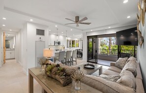 A modern living room with a sofa, a coffee table, and a dining area with chairs and a table. - Kaanapali Alii-3 Bedroom Ocean Views (Lahaina)