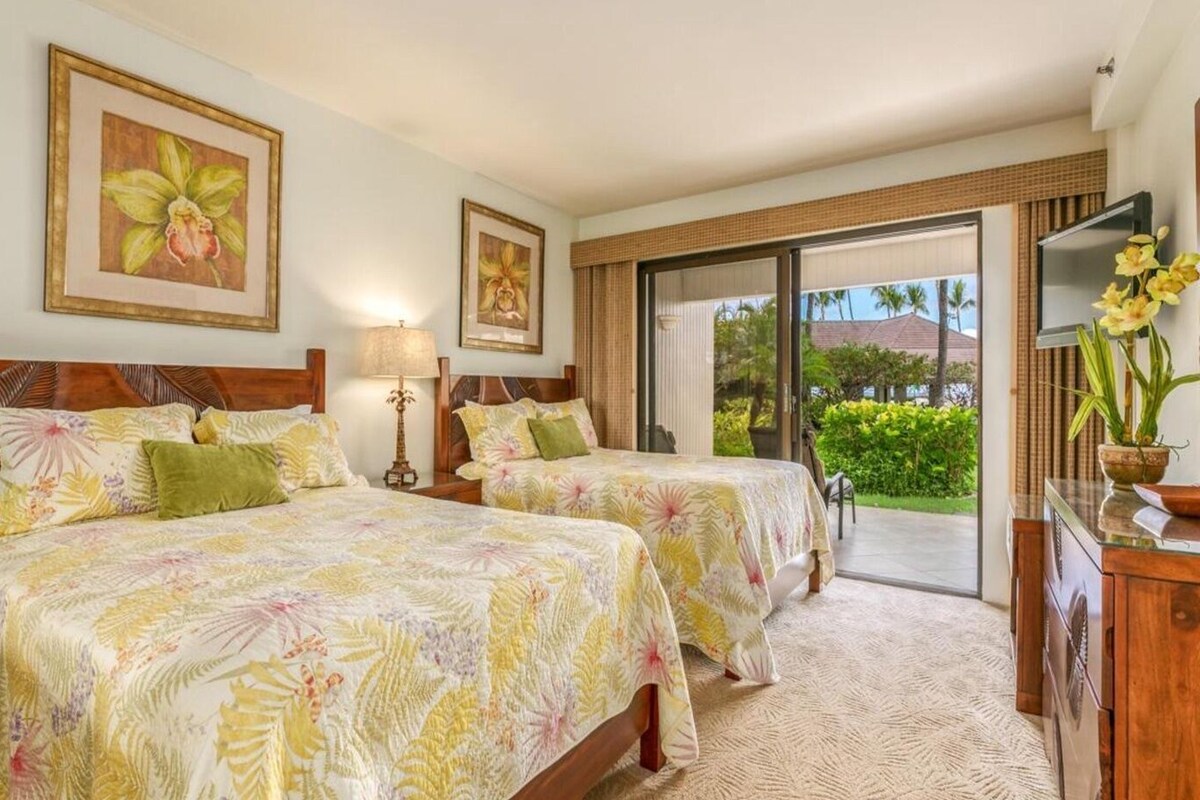 A hotel room with two beds, a large window, and a view of the outdoors.