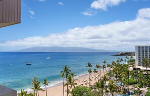A beach view with palm trees, a hotel, and boats on the water. - Kaanapali Alii-3 Bedroom Ocean Views (Lahaina)