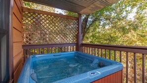 A hot tub under a wooden pergola with a lattice backdrop. - Hawks Nest #1907 (Sevierville)