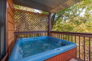 Ein Whirlpool unter einem hölzernen Pergola mit Gitterwerk im Hintergrund.