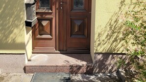 A wooden double door with a mailbox and a sign on the wall. - Cozy vacation apartment in the Hoher Fläming Nature Park with a spacious garden (Wiesenburg/Mark)