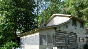 A log cabin with a large windowed porch, a grill, and Adirondack chairs. - Granny's River Retreat #458 (Gatlinburg)