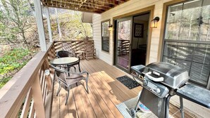 A wooden deck with a grill, chairs, and a table. - Winter Haven #1903 (Gatlinburg)