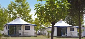Two yurts with a covered patio area, a table, and a chair. - Camping 3 étoiles - Parc aquatique - ccbg0hf (Garganvillar)