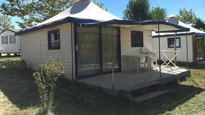 A mobile home with a covered patio, a small table, and a chair. - Camping 3 étoiles - Parc aquatique - ccbg0hf (Garganvillar)