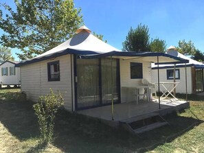 A mobile home with a covered patio, a small table, and a chair. - Camping 3 étoiles - Parc aquatique - ccbg0hf (Garganvillar)