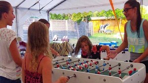 A group of people playing foosball under a tent. - Camping 3 étoiles - Parc aquatique - ccbg0hf (Garganvillar)