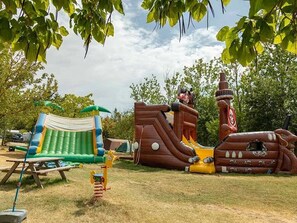 An inflatable play area with a slide, a tent, and a picnic table. - Camping 3 étoiles - Parc aquatique - ccbg0hg (Garganvillar)