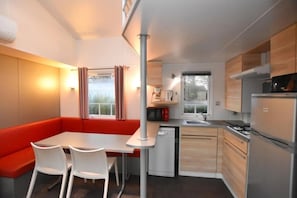 Een compacte keuken met een eethoek, een ingebouwde oven en een magnetron.