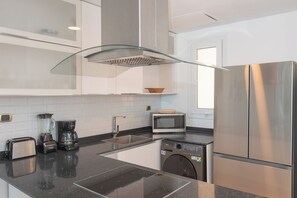 A modern kitchen with stainless steel appliances, a dishwasher, and a microwave. - Exquisite apt : Private beach : Swimming pool : 2BR (Punta Cana)