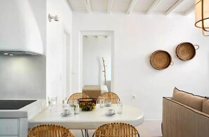 A modern kitchen with a dining area, white walls, and a ceiling with exposed beams. - Felicia Exclusive Villa - Private Pool (Arnados)