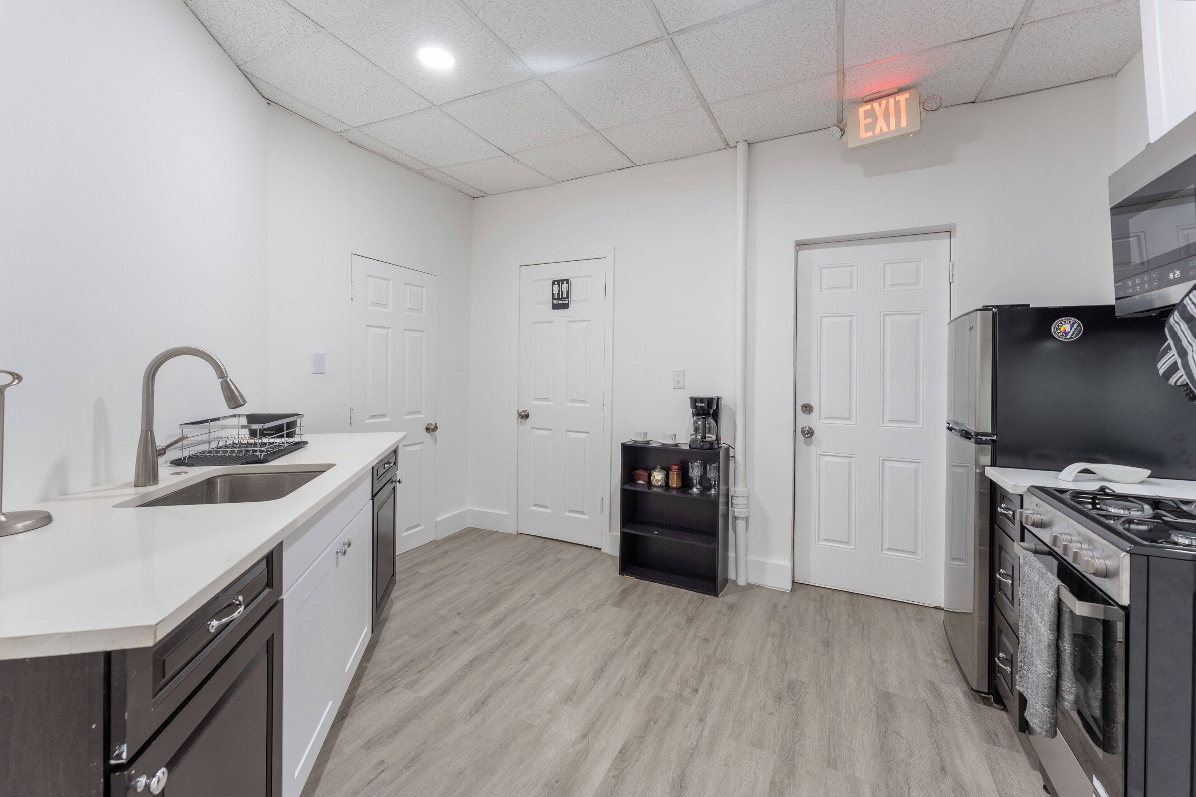 A modern kitchen with a sink, dishwasher, coffee maker, and a stove.