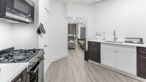 A modern kitchen with a stove, microwave, and dishwasher. - Spacious 3-bedroom apartment in gorgeous West New York with AC (West New York)